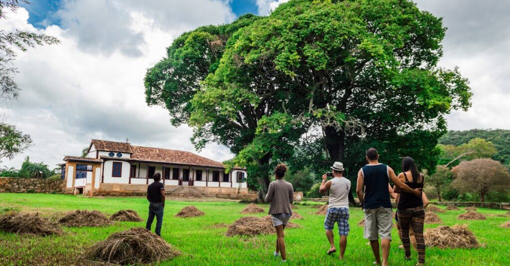 A group of adults enjoying an outdoor walk near a farmhouse surrounded by nature.